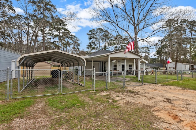 exterior space with a detached carport, a gate, driveway, and fence