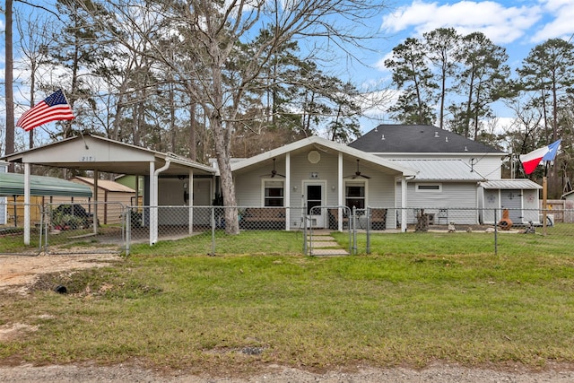 rear view of house with ceiling fan, a fenced front yard, dirt driveway, a yard, and a gate