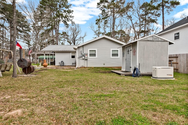 back of property with a storage shed, fence, a lawn, and an outdoor structure