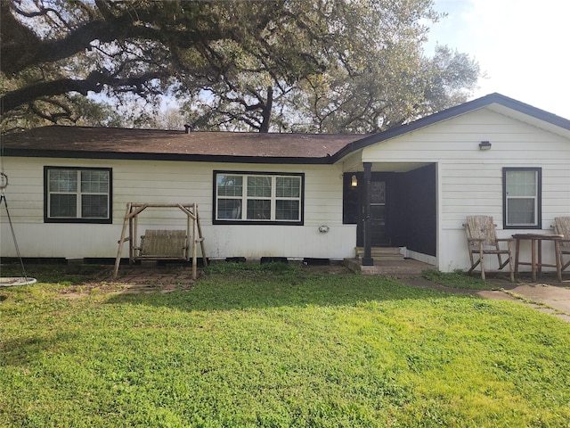 rear view of house featuring entry steps and a yard