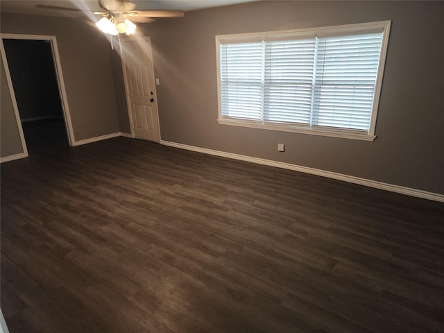 unfurnished room featuring ceiling fan, dark wood finished floors, and baseboards