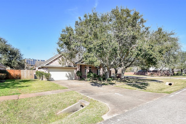 view of front of property with driveway, an attached garage, fence, a front yard, and brick siding