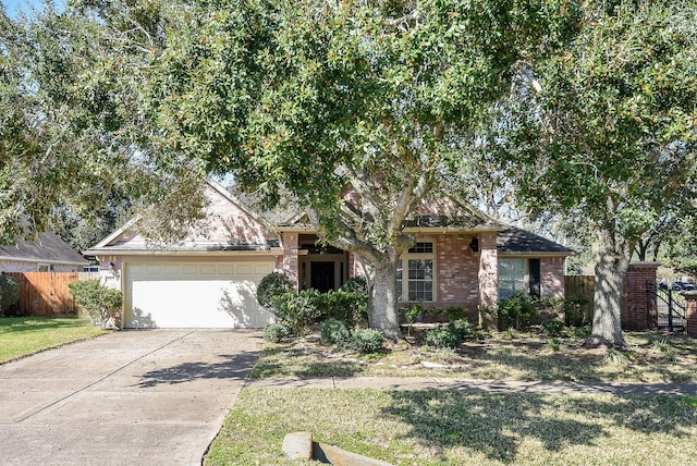 view of front of home with a garage, concrete driveway, brick siding, and fence