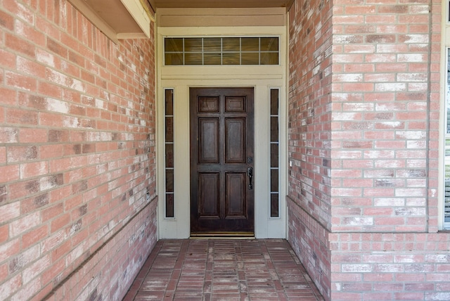 entrance to property featuring brick siding