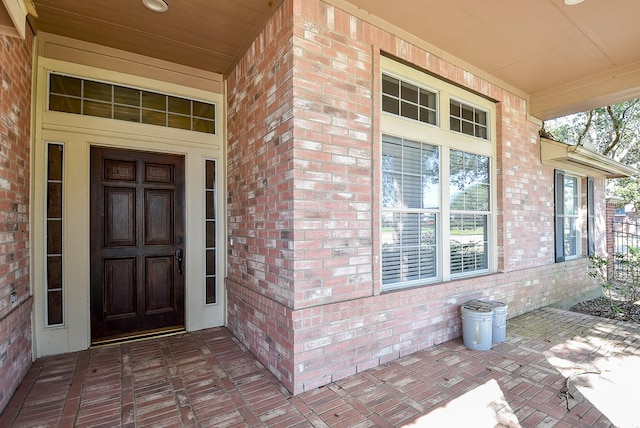 doorway to property featuring brick siding