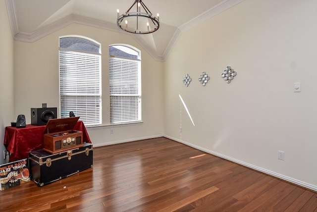 misc room featuring baseboards, lofted ceiling, hardwood / wood-style floors, crown molding, and a notable chandelier