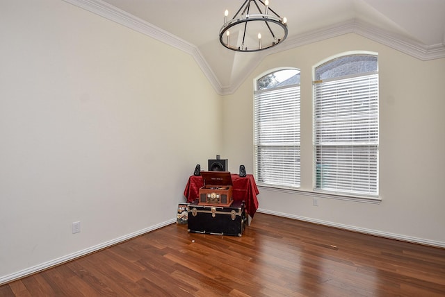 empty room featuring a chandelier, wood finished floors, lofted ceiling, and crown molding