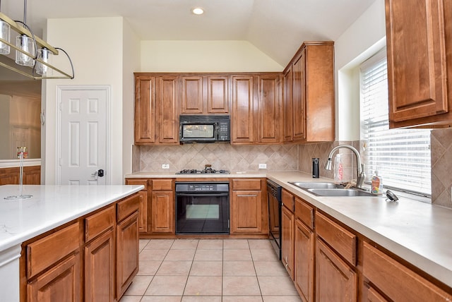 kitchen with brown cabinets, light countertops, light tile patterned flooring, a sink, and black appliances