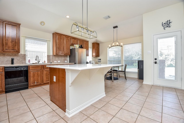 kitchen featuring freestanding refrigerator, black dishwasher, backsplash, and light tile patterned floors