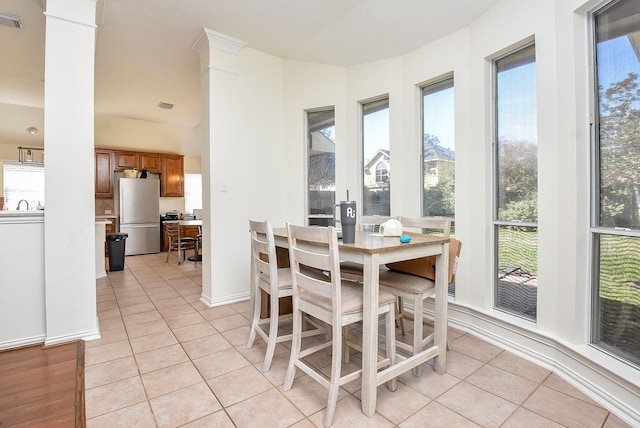 dining space featuring baseboards, visible vents, ornate columns, and light tile patterned floors