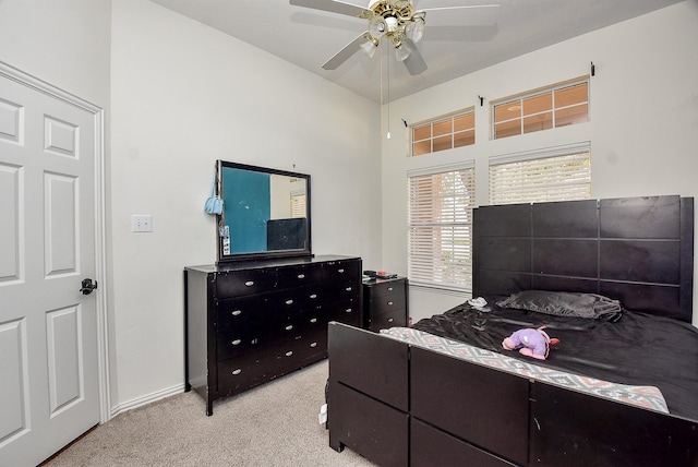 bedroom with light colored carpet, ceiling fan, and baseboards