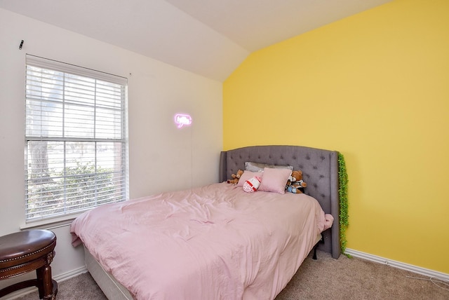 carpeted bedroom featuring lofted ceiling and baseboards