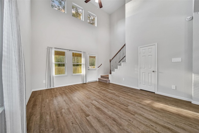 entryway featuring ceiling fan, stairway, wood finished floors, and a healthy amount of sunlight