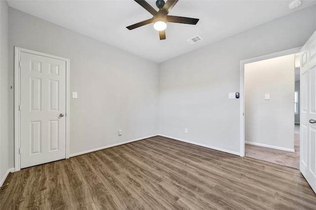 unfurnished room with baseboards, ceiling fan, visible vents, and wood finished floors