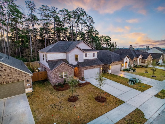 view of front facade featuring driveway, roof with shingles, a front yard, and fence