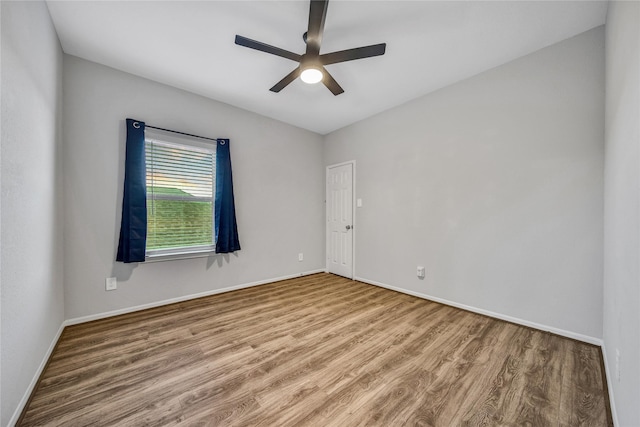 unfurnished room with a ceiling fan, baseboards, and wood finished floors