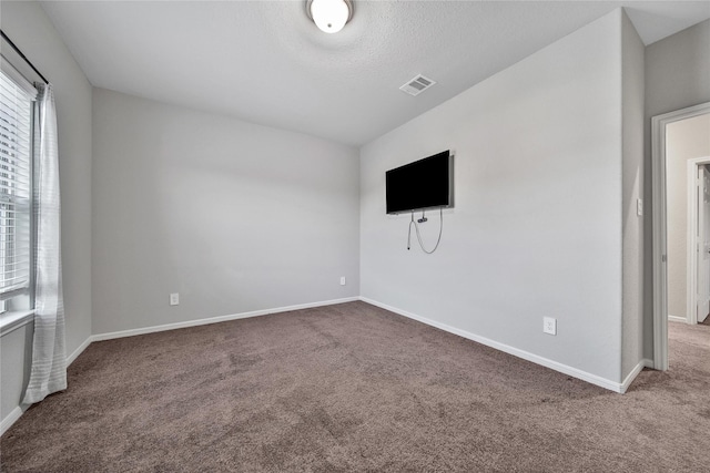 unfurnished living room featuring baseboards, a textured ceiling, visible vents, and carpet flooring