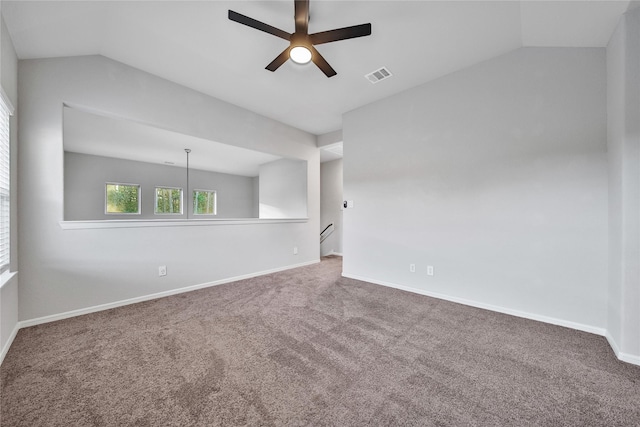 carpeted spare room with vaulted ceiling, a ceiling fan, visible vents, and baseboards