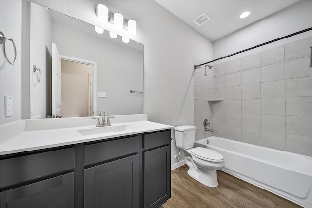 full bath with toilet, wood finished floors, vanity, visible vents, and shower / washtub combination