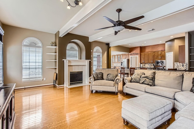 811 Piney Ridge Dr, Friendswood, TX 77546 - living area featuring ceiling fan, beamed ceiling, light wood-style flooring, healthy amount of natural light, and a tile fireplace