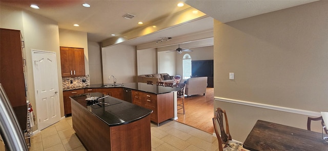 811 Piney Ridge Dr, Friendswood, TX 77546 - kitchen featuring a peninsula, brown cabinets, a ceiling fan, open floor plan, and tasteful backsplash
