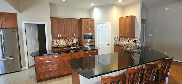 811 Piney Ridge Dr, Friendswood, TX 77546 - kitchen featuring stainless steel appliances, backsplash, a center island, a kitchen bar, and brown cabinets