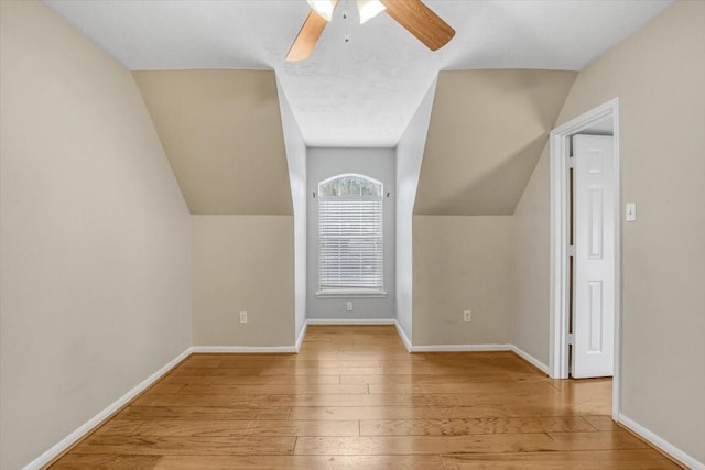 additional living space featuring baseboards, vaulted ceiling, and wood finished floors