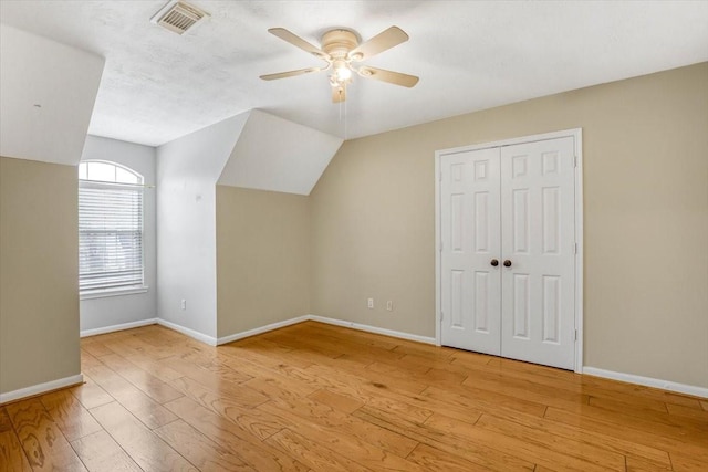 additional living space with baseboards, visible vents, and hardwood / wood-style floors