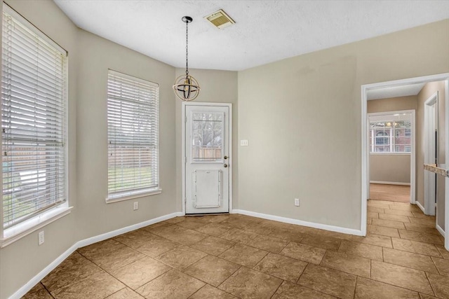 unfurnished dining area with baseboards and visible vents