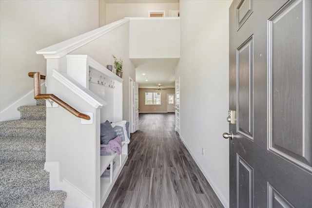 foyer featuring a high ceiling, stairway, wood finished floors, and baseboards