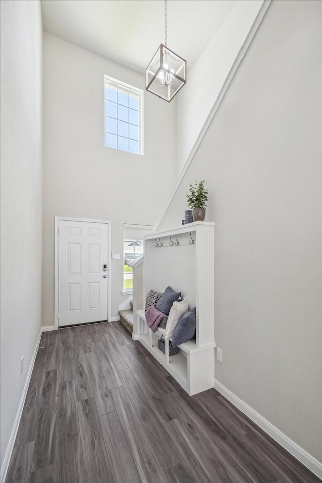 foyer with a chandelier, baseboards, wood finished floors, and stairs