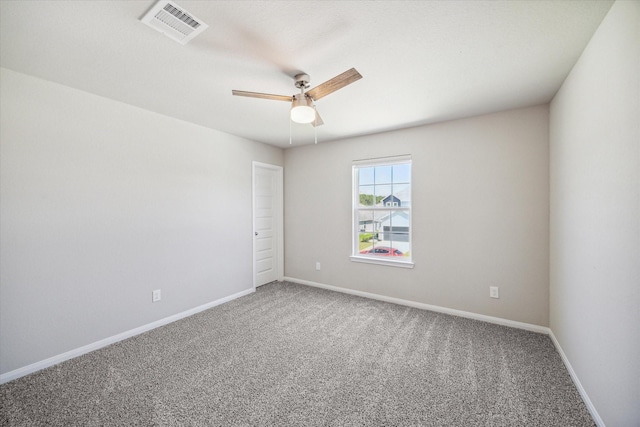 carpeted empty room featuring a ceiling fan, visible vents, and baseboards