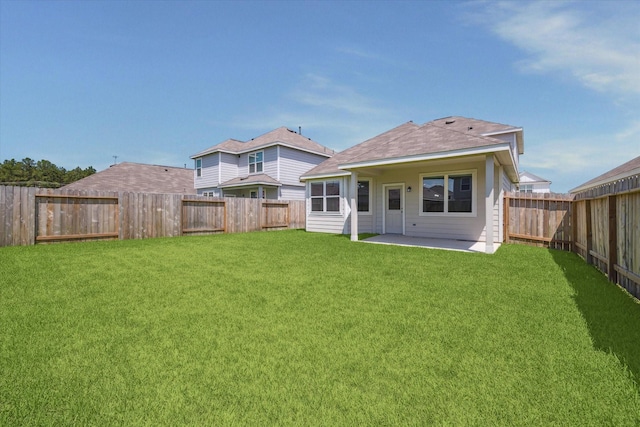 back of house with a fenced backyard, a patio area, and a yard