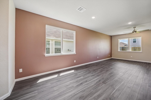 unfurnished room with recessed lighting, visible vents, baseboards, and dark wood finished floors