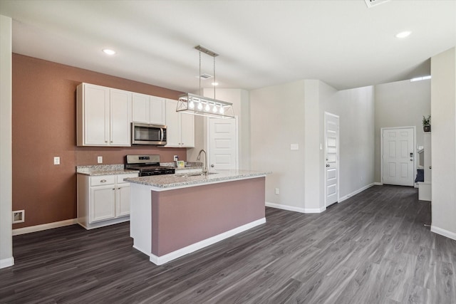 kitchen with a sink, appliances with stainless steel finishes, white cabinets, and dark wood finished floors