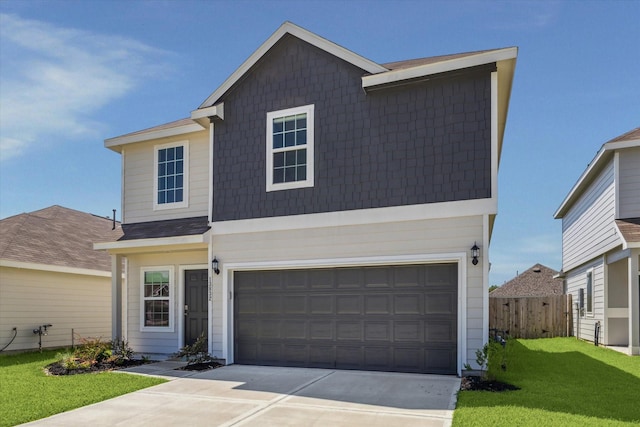 traditional home featuring a front lawn, concrete driveway, fence, and a garage