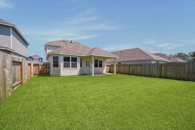 rear view of property with a lawn, a fenced backyard, and roof with shingles