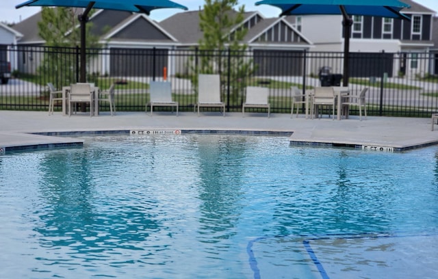 community pool featuring fence and a residential view