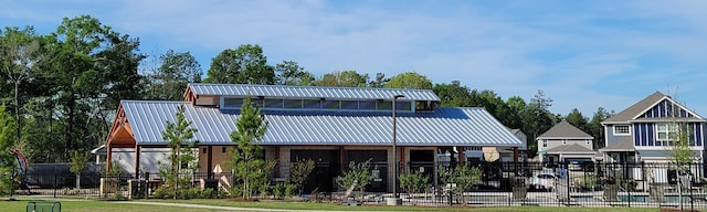 back of property featuring metal roof and fence