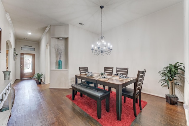 dining area featuring arched walkways, visible vents, baseboards, ornamental molding, and dark wood-style floors