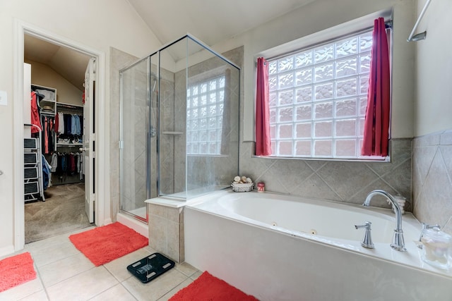 full bath featuring lofted ceiling, a garden tub, a shower stall, and tile patterned floors