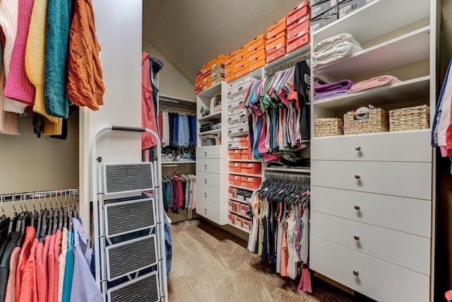 walk in closet with lofted ceiling and carpet flooring