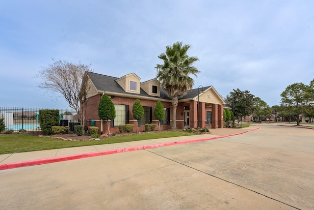 view of front facade featuring fence and brick siding