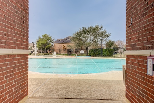 community pool featuring a patio area and fence