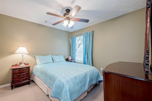 bedroom featuring baseboards, visible vents, ceiling fan, a textured ceiling, and light carpet