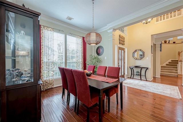 dining space featuring visible vents, wood finished floors, stairway, crown molding, and baseboards