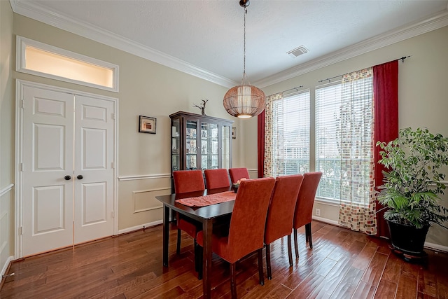 dining space with visible vents, crown molding, and dark wood-type flooring