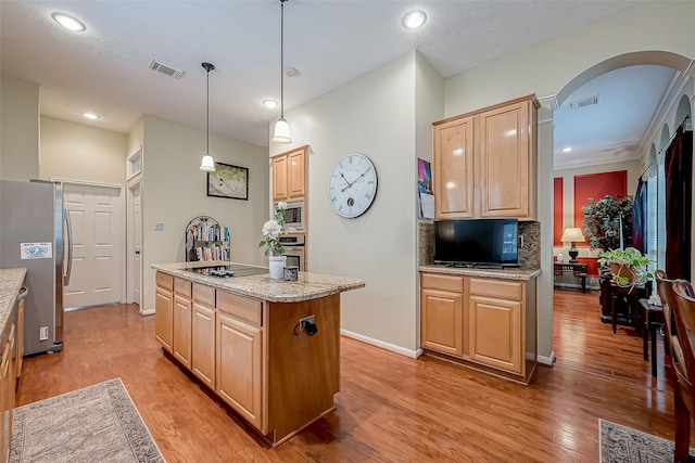 kitchen featuring visible vents, light brown cabinetry, stainless steel appliances, arched walkways, and light wood finished floors