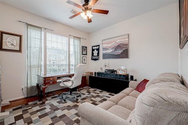 office area featuring visible vents, wood finished floors, baseboards, and ceiling fan