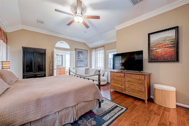 bedroom with visible vents, lofted ceiling, wood finished floors, and ornamental molding